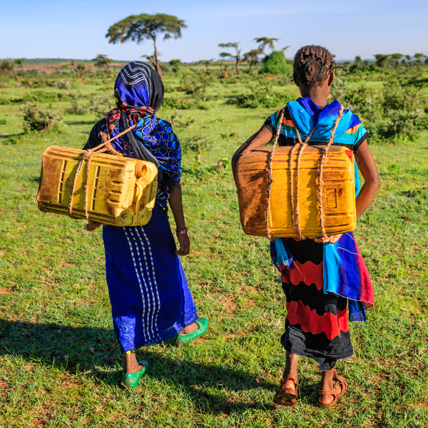 Young African girls carrying water from the well, Ethiopia, Africa